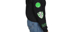Woman wearing black Dallas-themed crewneck sweatshirt with green and white custom patches on the right sleeve, including 214 area code and DALLAS hockey graphic. Streetwear fit from Sunday Club.